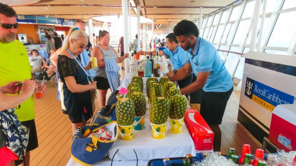 Waiters serve cruise passengers with drinks on Royal Caribbean’s Oasis of the Seas cruise ship by the pool deck on a sunny Caribbean day